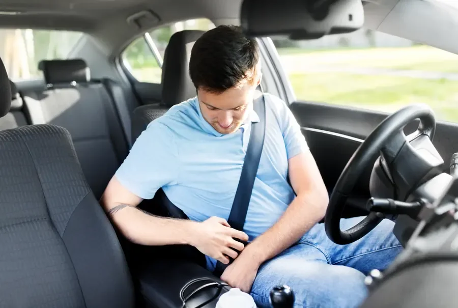 Driver fastening a seat belt in a fleet vehicle before setting off