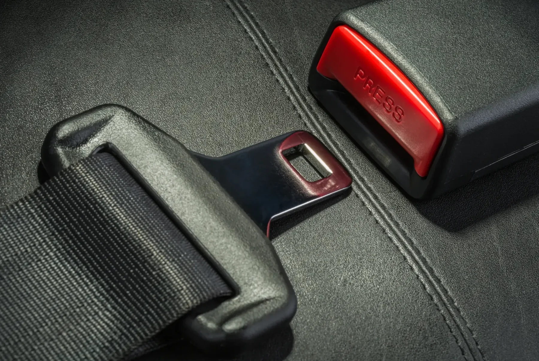 Seat belt latch plate engaged in a vehicle buckle receiver with a red release button