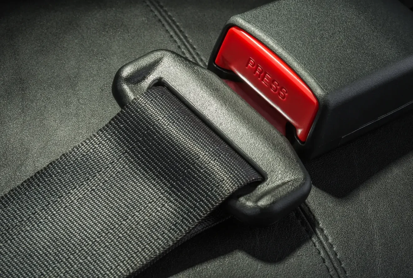 Close view of a seat belt assembly showing webbing, latch plate and buckle housing